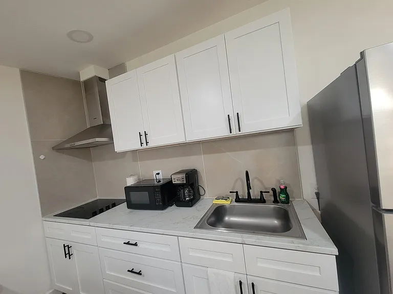 The kitchen includes a refrigerator, coffee maker, extractor hood and basic amenities