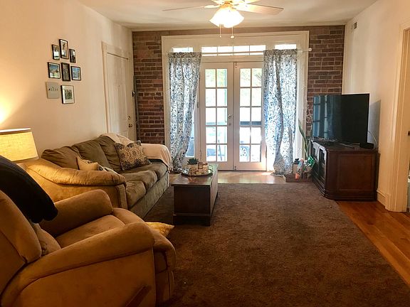 Living room with doors to the patio, nice exposed brick