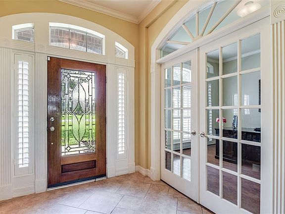Enter through leaded glass door with plantation shutters, patterned tile, and wonderful architectural features. French doors lead to the office.