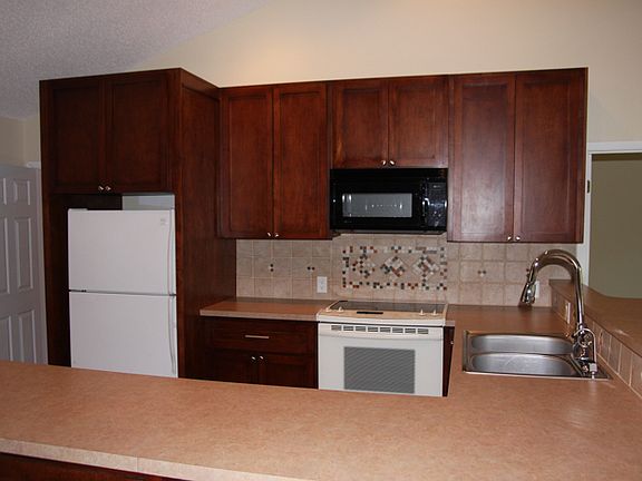 Tall cherry cabinets & tile.