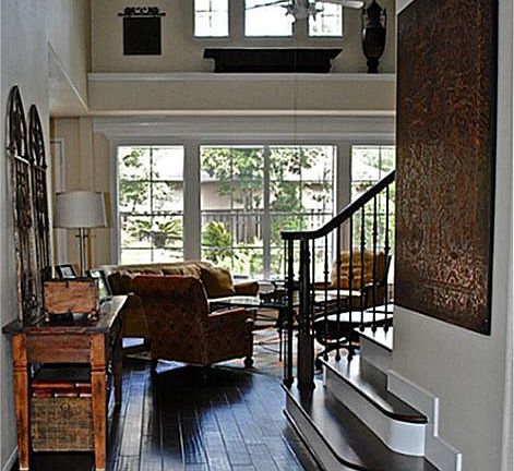 Grand entrance features a wrought iron staircase & wood floors.