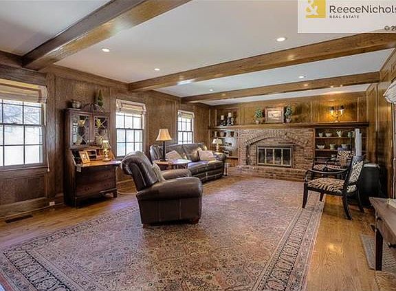 The large Family Room offers a cozy brick fireplace flanked with shelves.  Box beam ceiling, can lighting and hardwood floors enhance the beauty of this room.