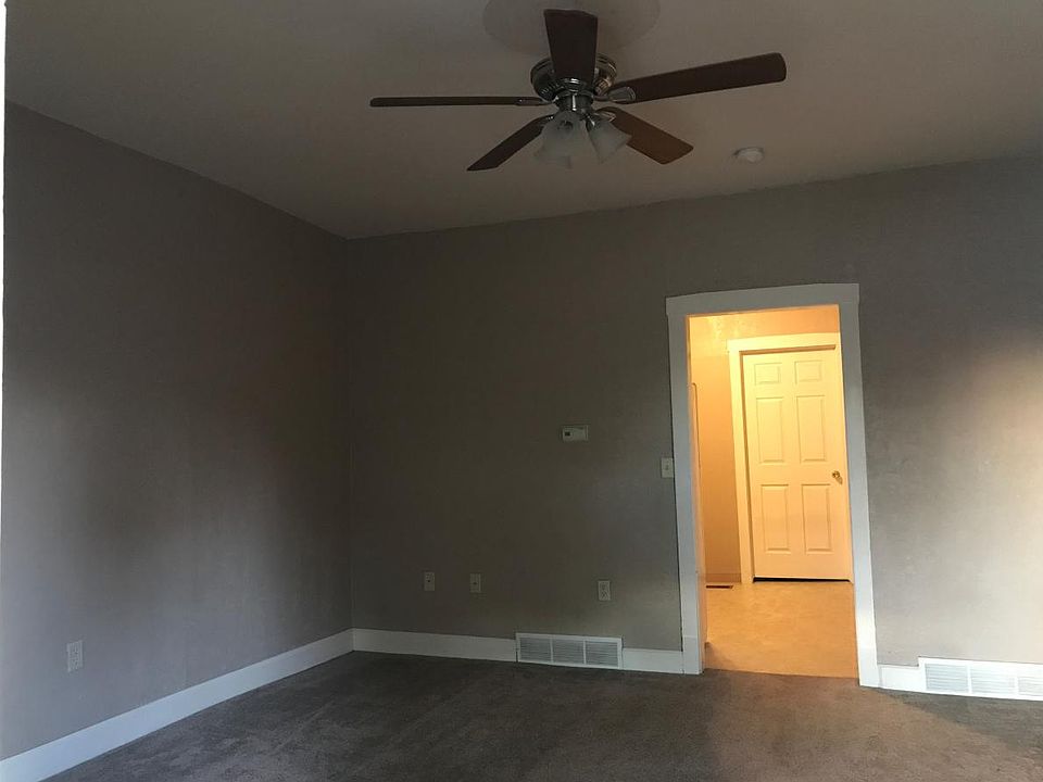 Living room with a newer carpet and ceiling fan.