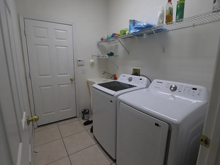 Laundry room with utility sink and brand new washer / dryer