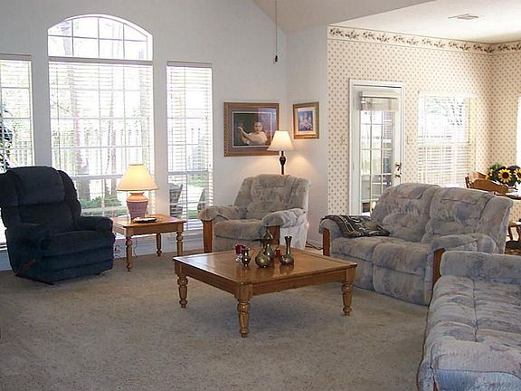 Bright and spacious great room or den with vaulted ceiling and tall windows