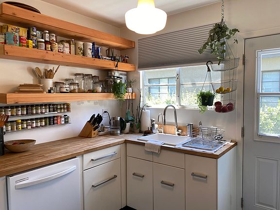 Kitchen with Farm Sink, Butcher Block Counters, Floating Shelves, Desk Nook and door to Private Side Yard *current dishwasher is stainless steel