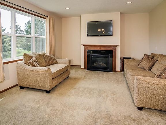 Spacious living area has a gas fireplace, recessed lighting and large windows.