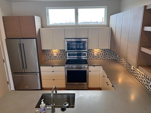 Gourmet kitchen with custom cabinets, backsplash, and kitchen aid appliances