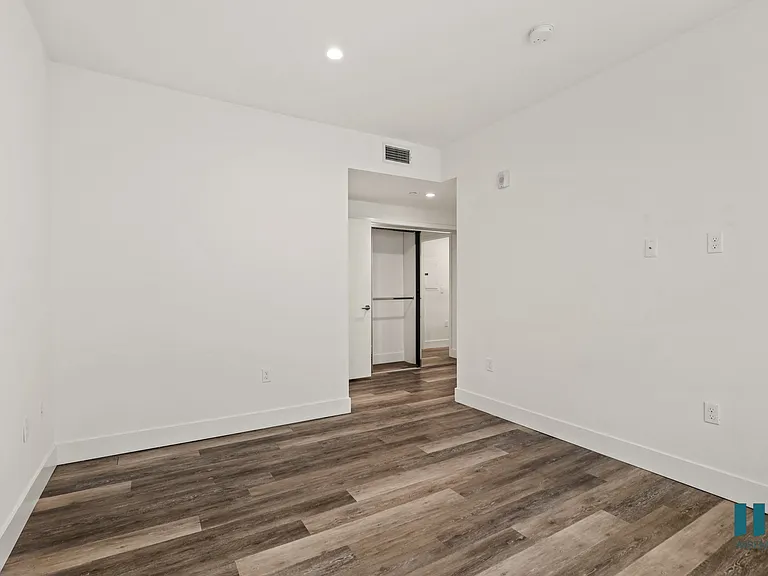 Bedroom with Vinyl Flooring and Mirrored Closets