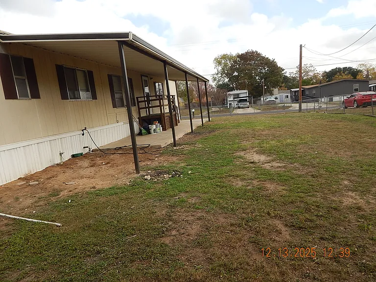 South side of home - showing large sized yard - patio cover- deck for front home entrance.