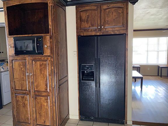 Opposite wall of kitchen. Large Pantry with pull out drawers, opening for microwave. Small utility room off kitchen.Refrigerator can be left but will not do repairs if it goes out.
