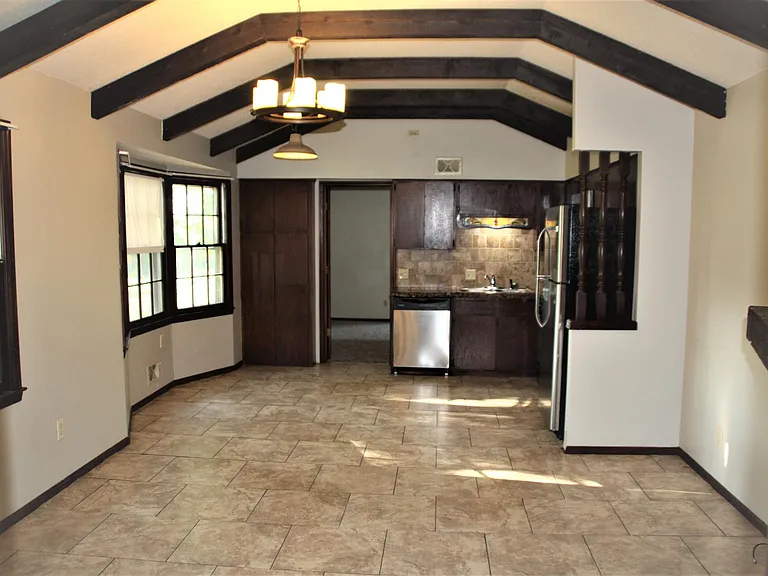 Vaulted Hearth room Kitchen. Kitchen with Stainless steel Refrigerator, Gas stove and built-in microwave. Concrete counters. Tile floors.