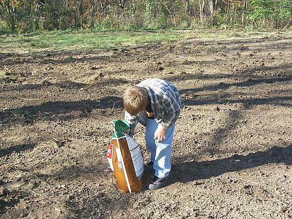 Spreading grass seed after house was removed