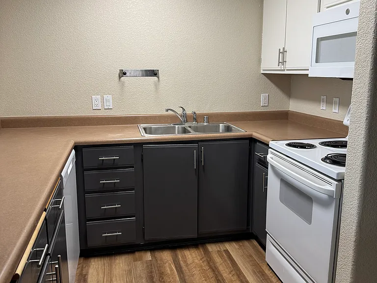 Kitchen featuring dishwasher, microwave, stove, and refrigerator, freshly painted cabinets