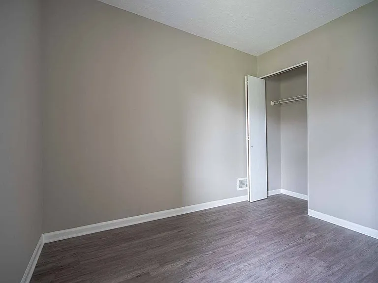 View of typical second bedroom with closet and faux plank flooring
