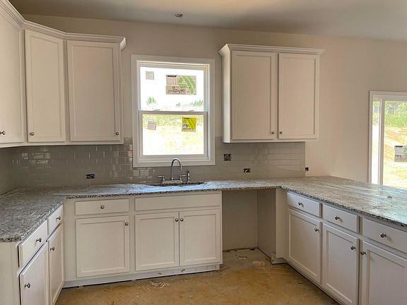 Kitchen with 42" White Cabinets, Granite counters, grey subway tile backsplash and Stainless Steel appliances.