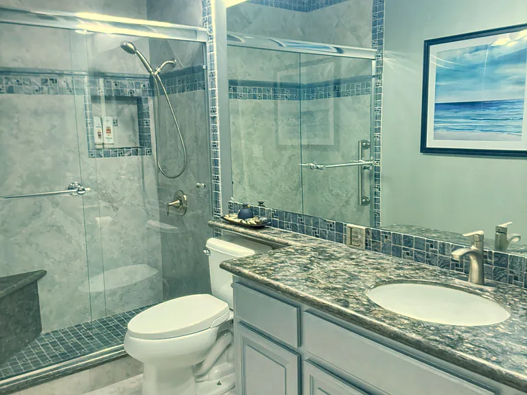 Color off-Hall bath, highly customized stone tiling, unique granite counters, large mirror