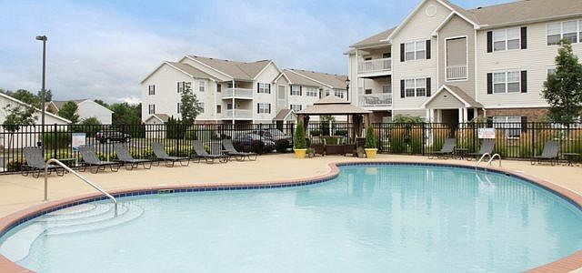 Sparkling pool area with gazebo couches, outdoor pool table and plenty of lounge chairs.