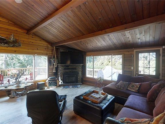 Great room Highlighted by Hardwoods, Gas Fireplace with Brick Surround and Picturesque Windows Looking Out to Your Private Retreat