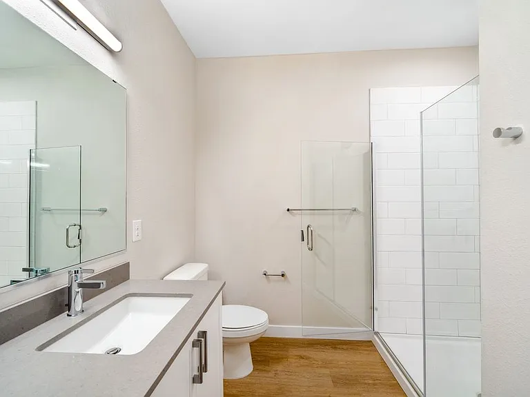 Finish Package I Bath with white cabinetry, grey quartz countertops, and hard-surface vinyl plank flooring