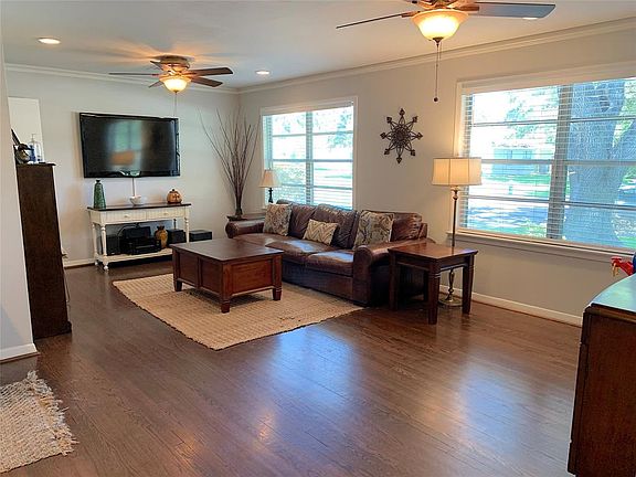 Spacious living room with bright big windows and ceiling fans. Recessed lights & Crown molding.