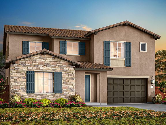 A two-story Mediterranean-style house with a stone facade, tiled roof, and a well-manicured front ya