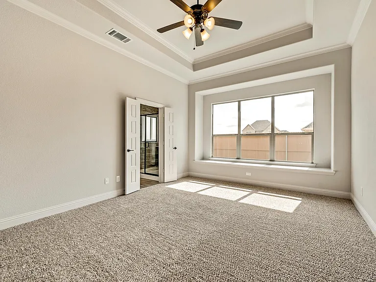 Large mater bedroom with view of yard & window seat