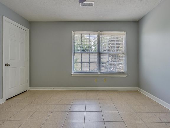3 bedroom flat living room, tile flooring, ceiling fan.