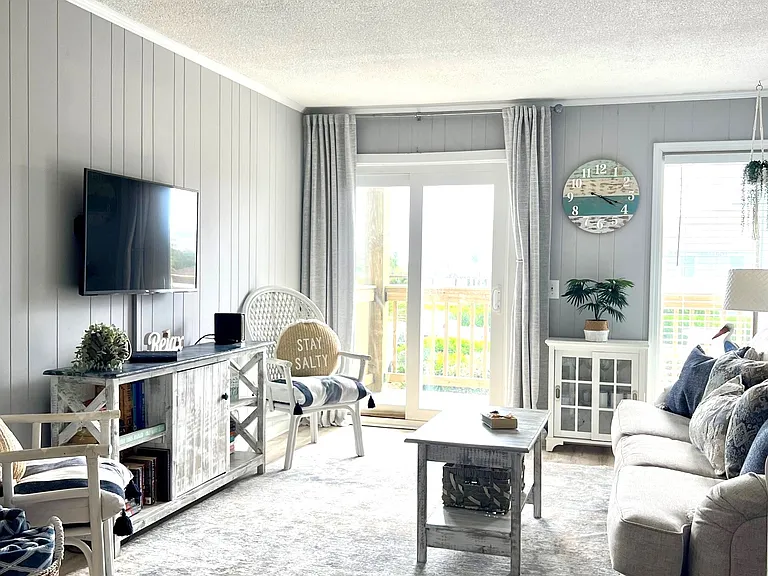 Family room with games cabinet, books, and blackout curtains.