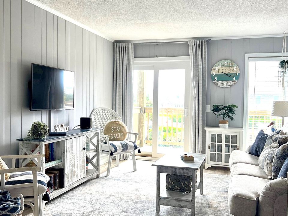 Family room with games cabinet, books, and blackout curtains.