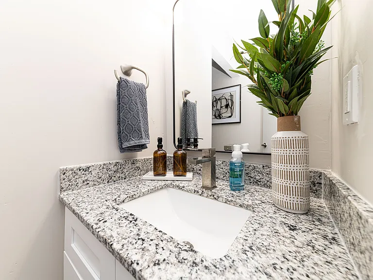 Bright bathroom with granite counters and high rise faucet