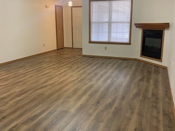 From Dining room looking back to Coat closet on left, Garage door in center, entry door, unseen, on right. Living room double widows for lots of light and a gas fireplace with Oak mantle.