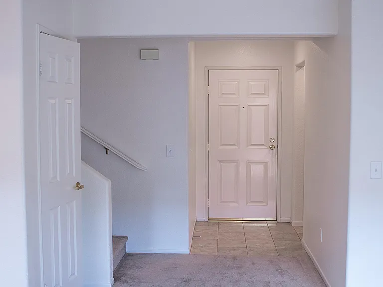 Front door entrance leading to 1st floor bedroom and full bathroom, stairs for 2nd floor bedrooms, huge walk-in storage closet, and living room