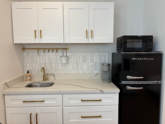 Kitchenette with quartz countertop and ample storage.