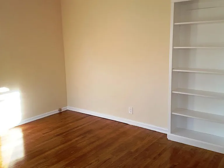 Bedroom with wood floor and built-in