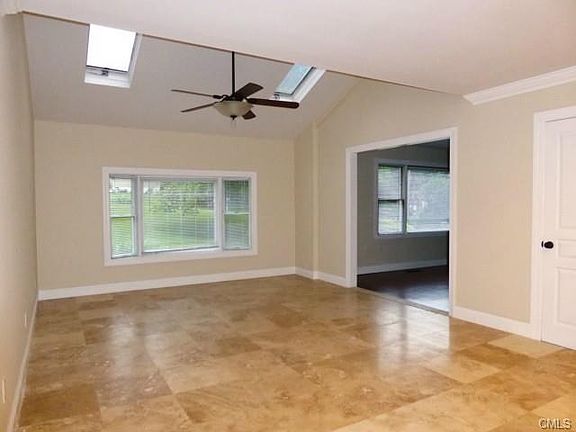 Stunning great room with skylights and ceiling fan, quality tile flooring