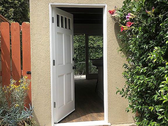 Welcoming, private garden entrance. Gate at left secures outdoor storage for bike, surf board, etc.