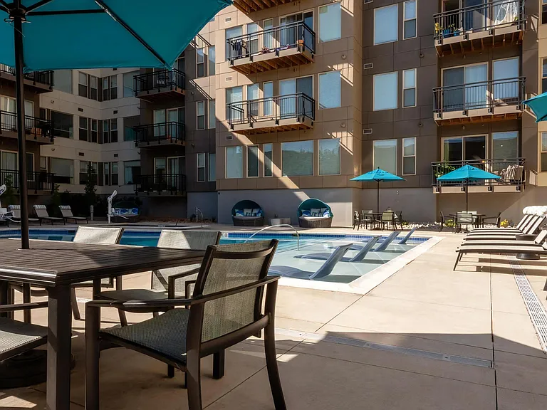 Outdoor Pool Surrounded by Lounge Chairs and Umbrella Seating