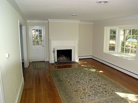 Living Room w/ refinished hardwood, fireplace,crown molding & sunny bay window