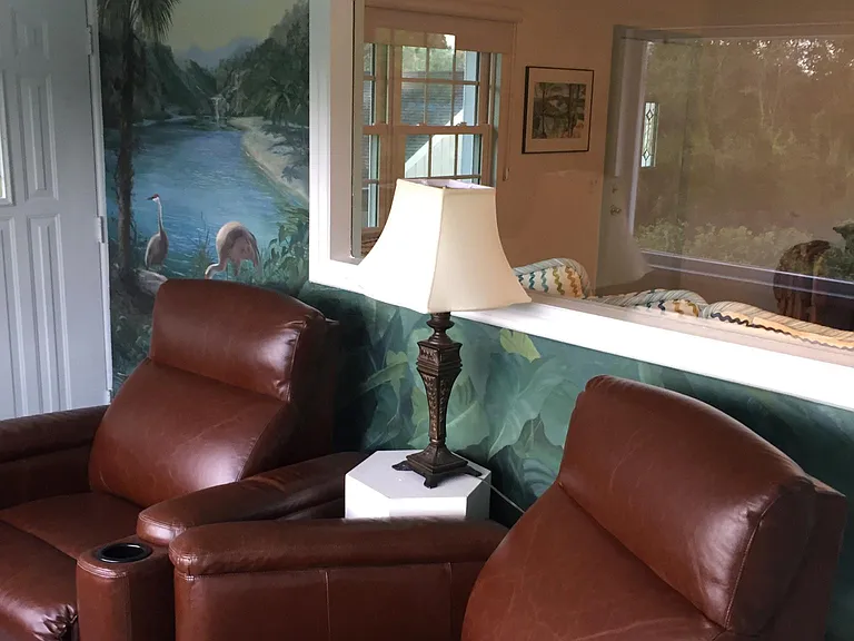 Sunporch with electric wall-hugging recliners and wrap around custom mural by Bellearte Studio.