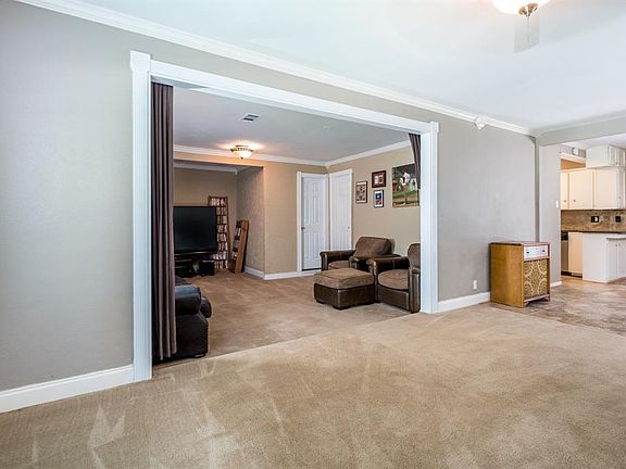 Family room has crown molding and fan.