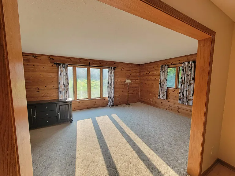 Large family room with real wood paneling. Overlooking orchard.