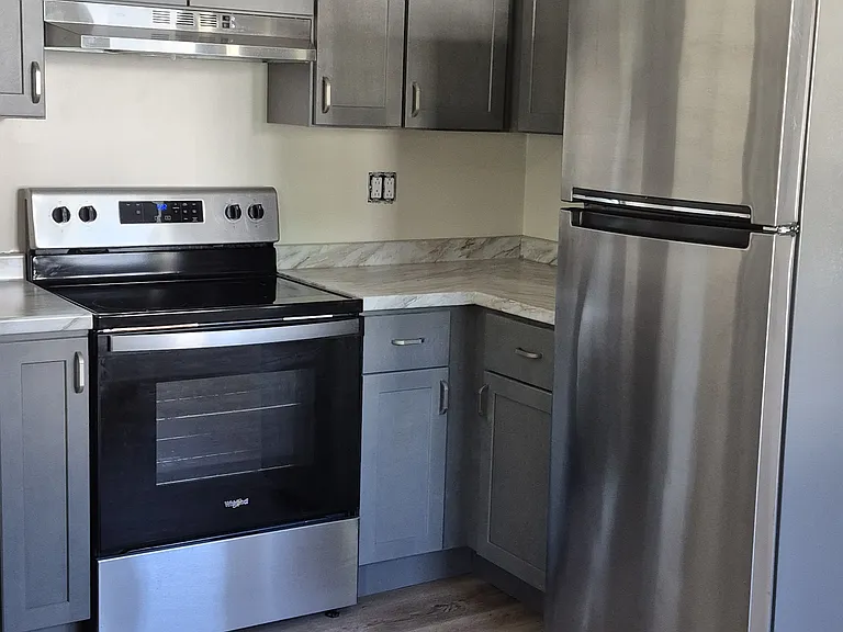 Electric stove with exhaust fan. Cabinets and countertop space as needed
