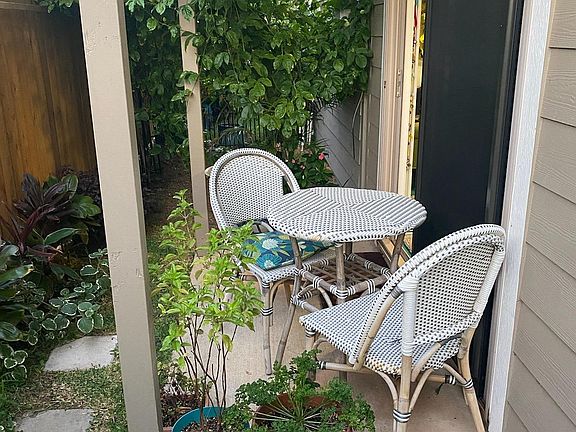 Outdoor dining table at entry to unit.