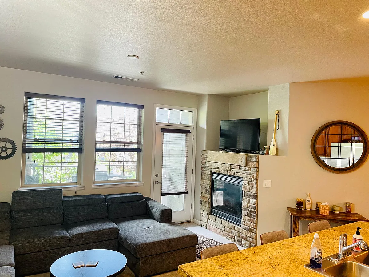 Living room with fireplace and walkout patio. - 152 Village Rd #B-104