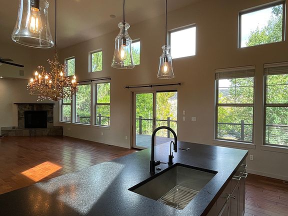 Open-plan living area features a gas fireplace, abundant light from multiple windows and showcases views of the Roaring Fork Valley