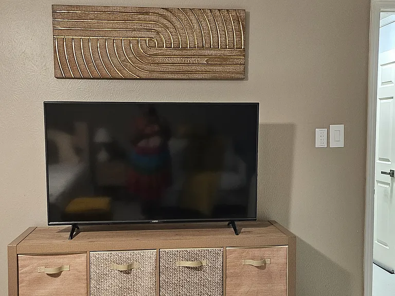 56 inch Smart TV with remote.
Storage unit with baskets.
