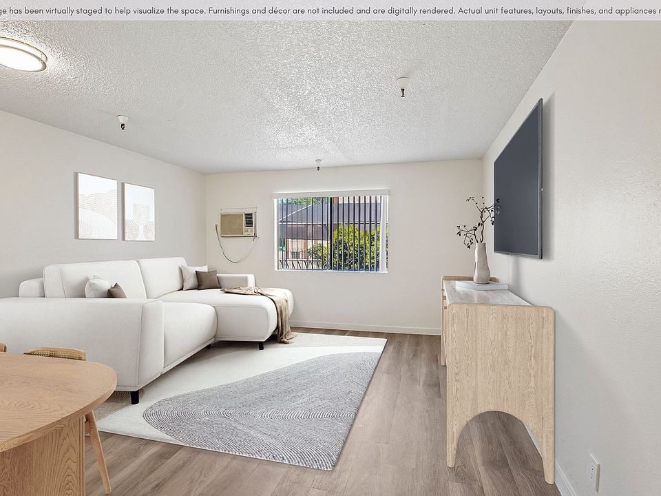Bright and inviting living area with updated flooring, natural light, and a spacious open layout.