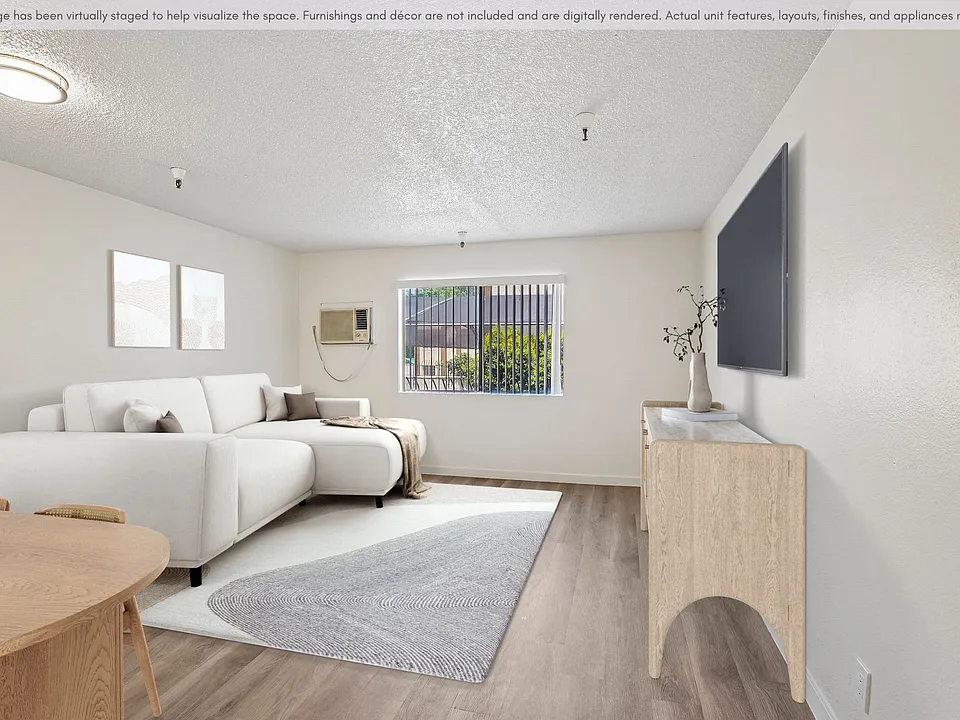 Bright and inviting living area with updated flooring, natural light, and a spacious open layout.