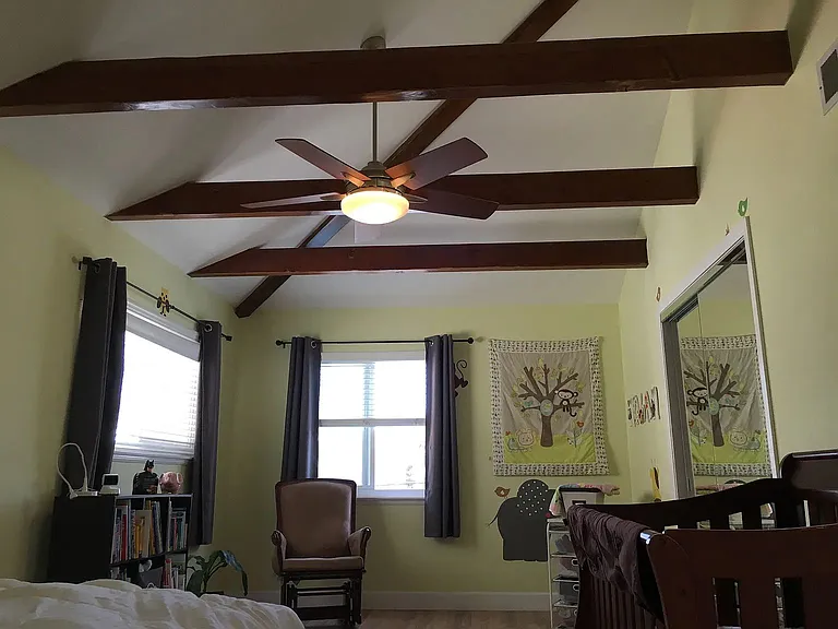 The second bedroom, also equipped with the stylish wood beam ceiling.